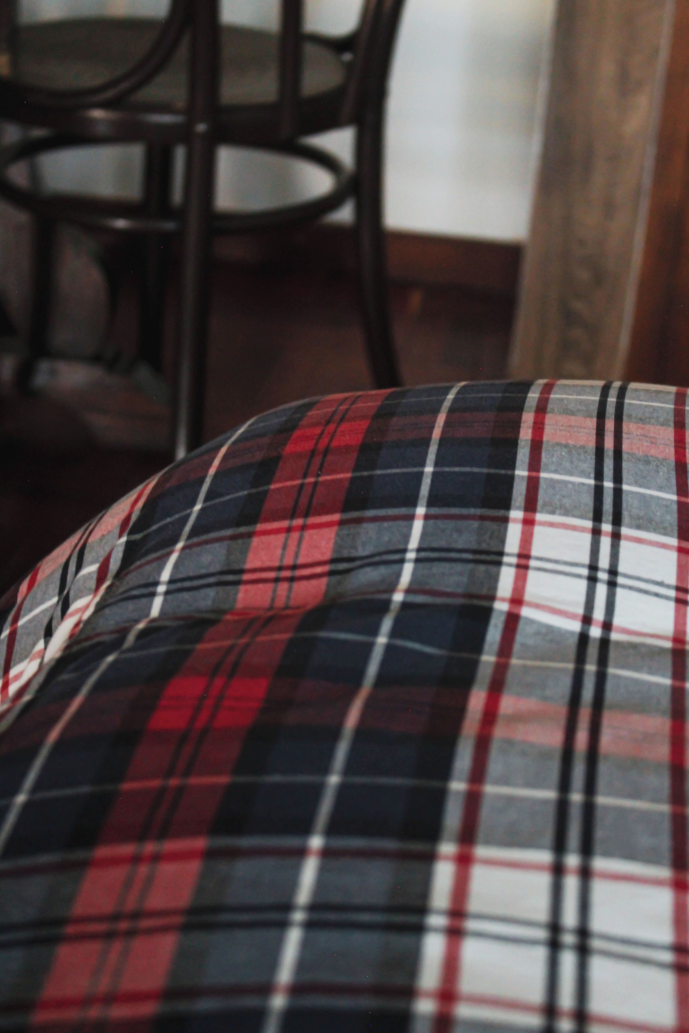 Cuscino a motivi tartan con un logo ben visibile.