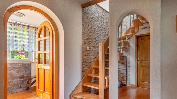 A spacious room with a wooden staircase, a stone wall, and a large wooden door. - Haus Polivka by Interhome (Hurka u Nemcice)