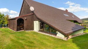 A large barn with a sloped roof, a satellite dish, and a door leading to a covered area with logs. - Haus Polivka by Interhome (Hurka u Nemcice)