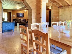 L’intérieur est en bois et comprend une table à manger pour six personnes, un canapé en cuir et un téléviseur fixé au mur.