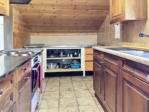 A kitchen with wooden cabinets, a countertop, and a stove. - Chalet Anthamatten by Interhome (Champery)