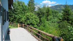 A gravel path leading to a wooden fence overlooking a lush green landscape with trees and distant mountains. - Landhaus Grüne Oase by Interhome (Öblarn)