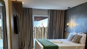 A modern hotel room with a large bed, a bedside table, a mirror, and a view of the outside. - Maré do Frances (Marechal Deodoro)