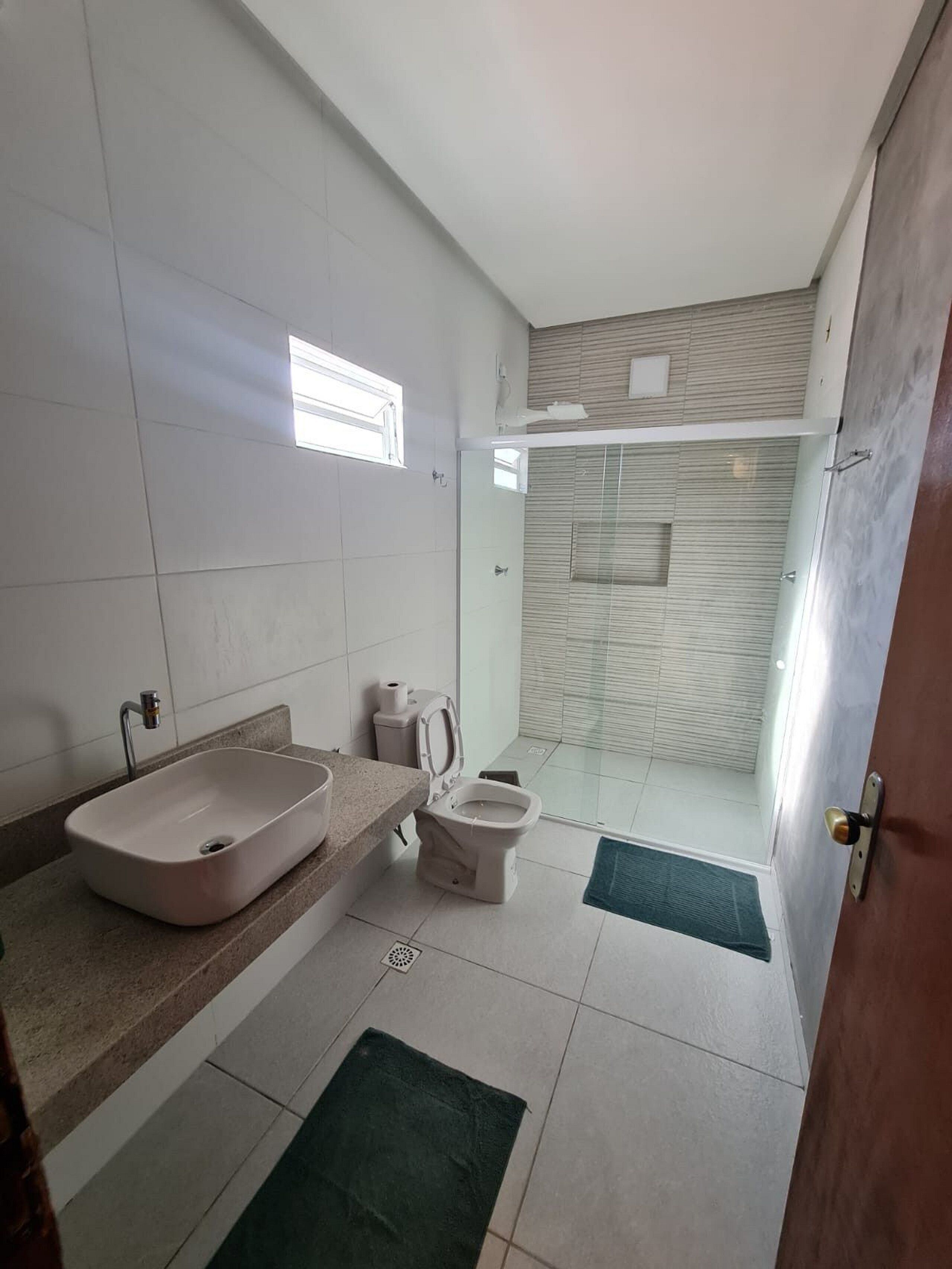 A modern bathroom with a sink, toilet, and shower area.