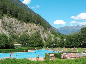 A swimming pool surrounded by lush greenery and mountains. - Piz Munschuns by Interhome (Spiss-Samnaun)
