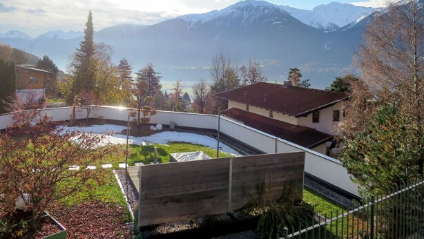 Zona residencial con vistas a montañas nevadas y un lago.