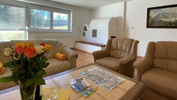 A living room with two sofas, a coffee table with magazines, a vase with flowers, and a painting on the wall. - Vacation home Anger by Interhome (Angerberg)