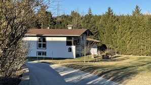 A two-story house with a brown roof, surrounded by dense forest and power lines. - Vacation home Anger by Interhome (Angerberg)