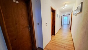 A hallway with wooden flooring and doors, including a door labeled "WE". - Oberhaus by Interhome (Finkenberg)