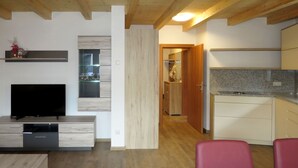 Una cocina moderna con armarios de madera, horno empotrado y encimera de granito.