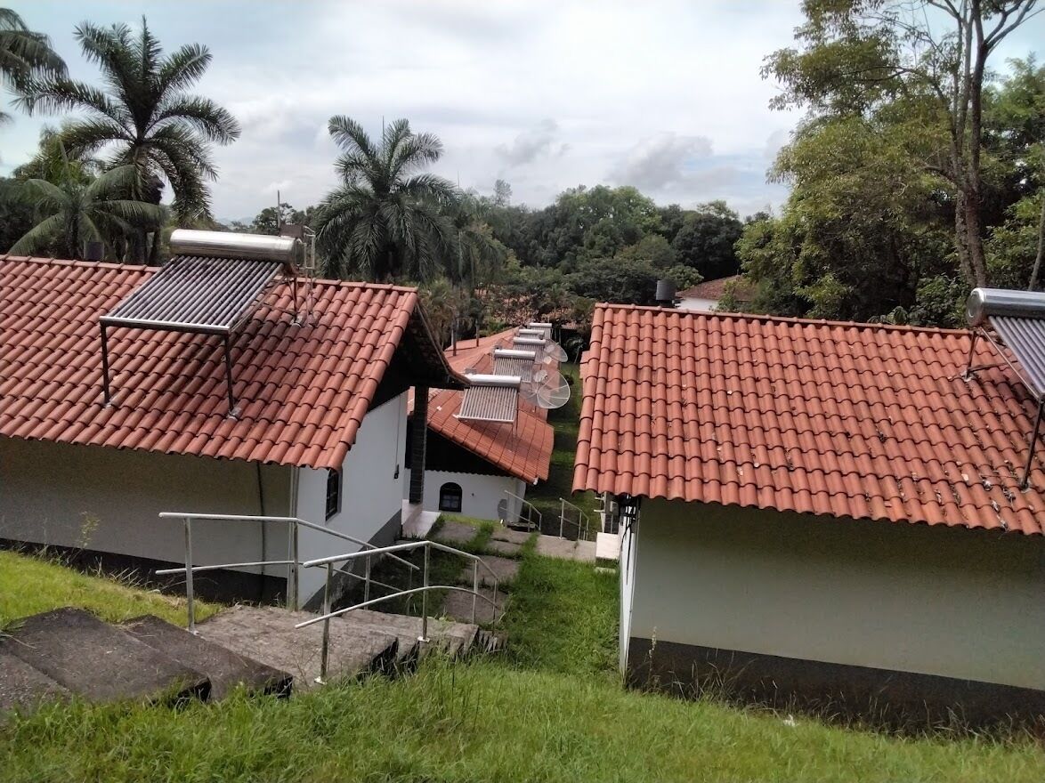 A residential area with houses featuring red-tiled roofs and solar panels.