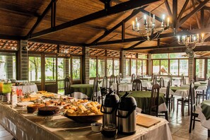 Montaje de bufé con diferentes opciones de comida y dispensadores de bebidas calientes.