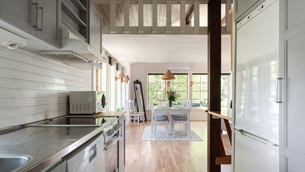 A kitchen with a large island, white cabinetry, and a view to the dining area.