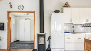 Een moderne keuken met witte kastjes, een zwarte kookplaat en een koelkast.