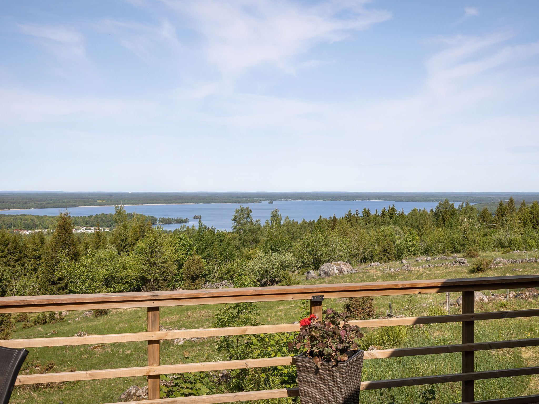 A wooden deck with a view of a lake and forest.