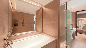 A modern bathroom with a large bathtub, a glass shower enclosure, and a vanity with a mirror.