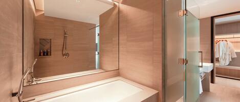 A modern bathroom with a large bathtub, a glass shower enclosure, and a vanity with a mirror.