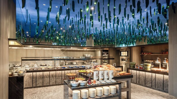 A modern buffet setup with a variety of food items and a unique ceiling design. - Holiday Inn Kuala Lumpur Bangsar by IHG (Kuala Lumpur)