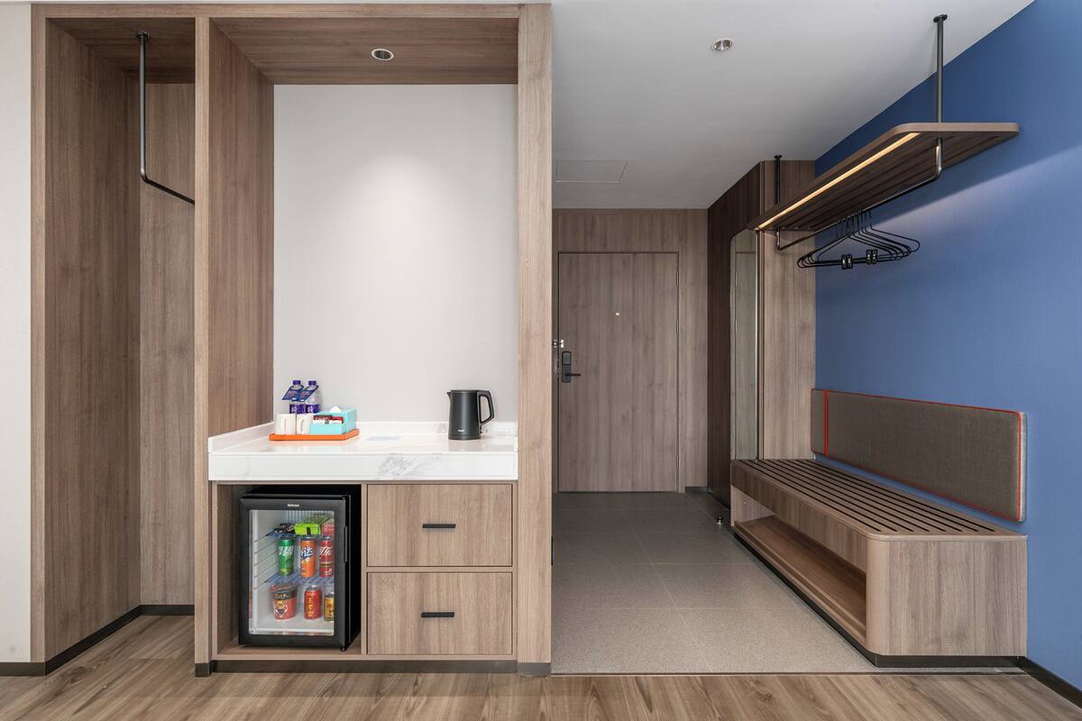 Eine kleine Küchenzeile mit Kühlschrank, einer Kaffeemaschine und einer Arbeitsplatte.