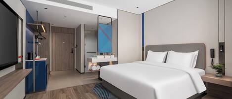 Una habitación de hotel moderna con una cama grande, televisión, escritorio y baño.