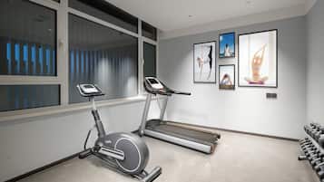 A modern home gym with an elliptical, treadmill, and dumbbells.
