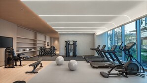 Un gimnasio moderno con cintas de correr, elípticas y equipo de levantamiento de pesas.