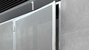 A metal security gate with a keypad lock, set against a grey wall with a tiled floor. - Apartamento Presidente 1 (Sevilla)