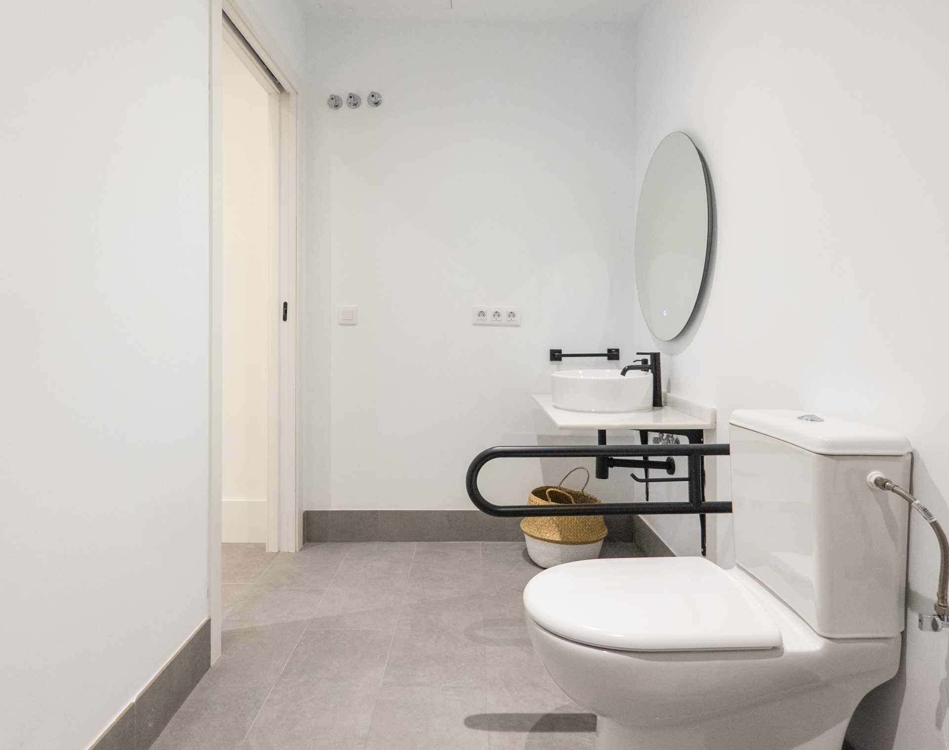 Ein modernes Badezimmer mit Toilette, Waschbecken und Spiegel.
