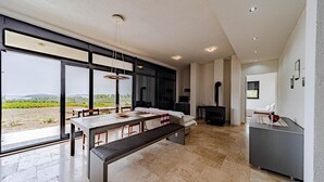 A modern kitchen with a large dining table, bench, and a fireplace.