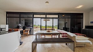 A modern kitchen with a dining area, large windows, and a view of the countryside.