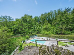 A pool area with a view of a forested hillside.
