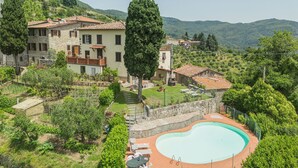 A villa with a swimming pool surrounded by lush greenery and hills. - Vacation home Sara by Interhome (Gello)