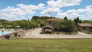 A stone villa with a pool, surrounded by a stone wall and lush greenery. - La Mangiatoia (TER104) by Interhome (Terricciola)