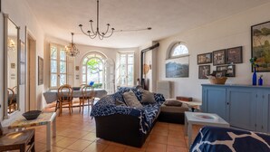 Un salon spacieux comprenant un canapé, une table à manger avec des chaises et un coin cuisine avec un meuble de rangement.