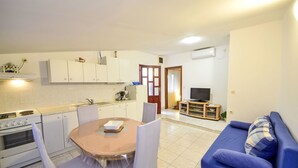 A compact living space with a kitchen, dining area, and a sofa. - Apartment Peric by Interhome (Korčula/Korčula)