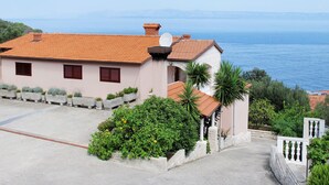A coastal house with a red-tiled roof, a satellite dish, and a view of the sea. - Apartment Peric by Interhome (Korčula/Korčula)