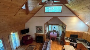 A cozy cabin interior with a dining area, kitchen, and seating space.