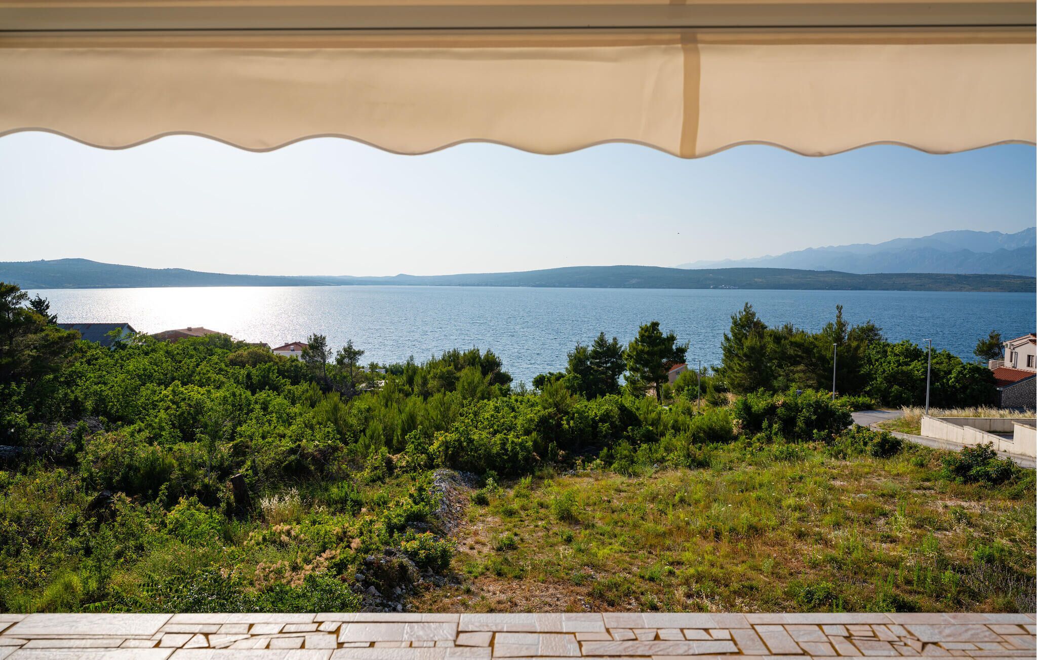 A terrace with a view of a lake and distant mountains.
