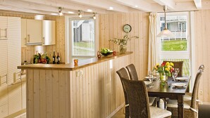 Un interior de madera con una isla de cocina, una mesa de comedor y sillas.