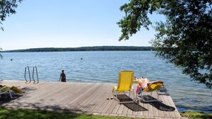 A wooden dock with two yellow lounge chairs and a metal pool ladder. - Falster by Interhome (Bad Saarow)