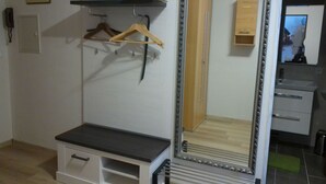 Une chambre à coucher avec un lit, une armoire, un miroir et un petit bureau.