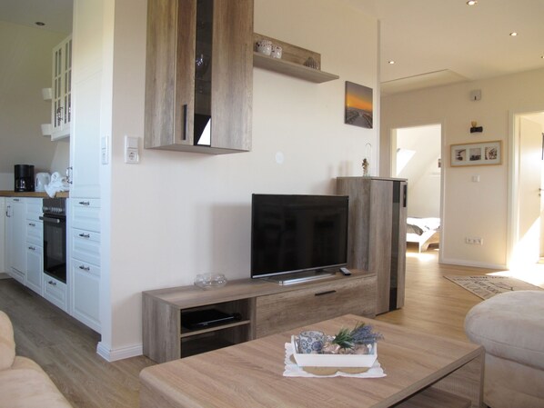 A modern living room with a TV, wooden cabinets, and a dining area. - Hannelore by Interhome (Hohenkirchen)