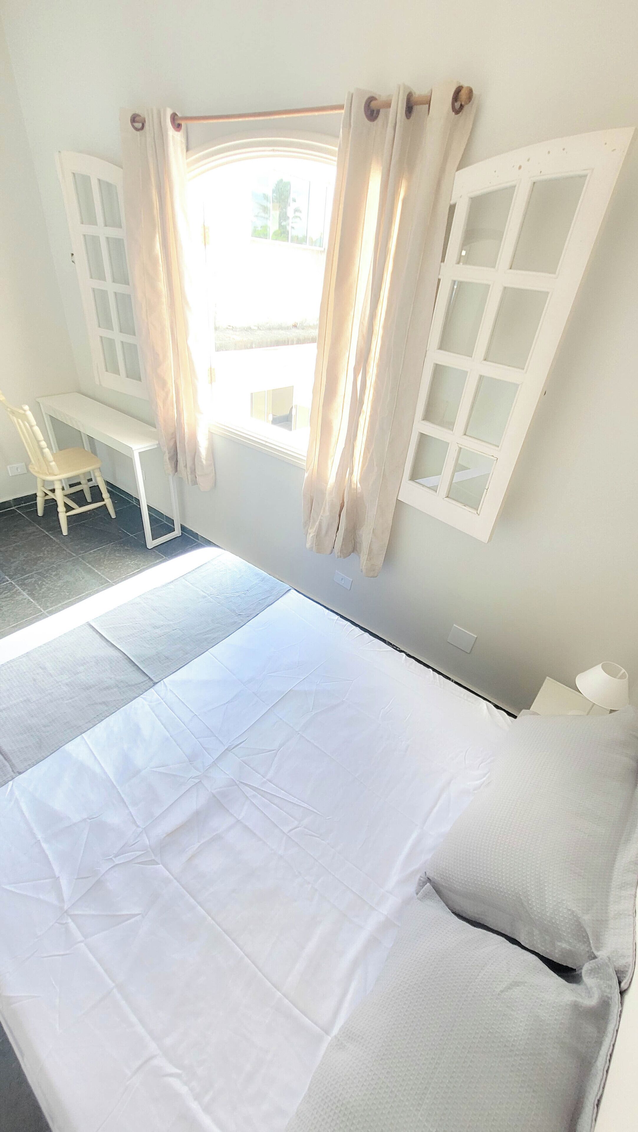 Een kamer met een bed, een bureau en een stoel.