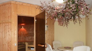 Una sauna in legno con una panca e un tavolo con sedie.