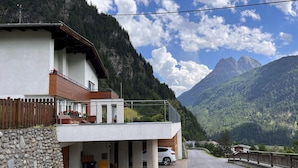 Ein modernes Gebäude mit einem Balkon mit Blick auf eine Berglandschaft.