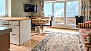 Ein kompakter Wohnbereich mit Küchenzeile, Essbereich und einer Couch.