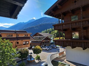 Un bâtiment en bois doté d’un balcon, d’un espace de stationnement et offrant une vue sur la montagne.