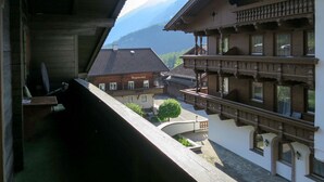 A traditional chalet with a balcony overlooking a mountain view.