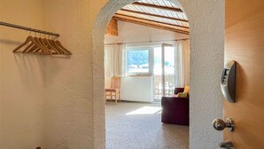 A hallway leading to a room with a wooden ceiling, a coat rack, and a door with a digital lock. - Apartment Rofan by Interhome (Achensee)