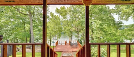 A wooden deck with a view of a lake and trees.